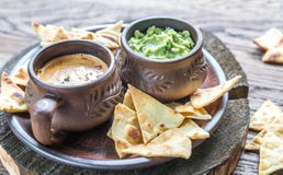 Κύπελλα του guacamole και του queso με tortilla τα τσιπ στοκ εικόνα με δικαίωμα ελεύθερης χρήσης Κύπελλα του guacamole και του queso με tortilla τα τσιπ στοκ εικόνα με δικαίωμα ελεύθερης χρήσης