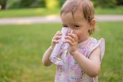 Λίγο μωρό είναι πόσιμο νερό από το γυαλί στην ηλιόλουστη καυτή ημέρα στοκ φωτογραφία με δικαίωμα ελεύθερης χρήσης Λίγο μωρό είναι πόσιμο νερό από το γυαλί στην ηλιόλουστη καυτή ημέρα στοκ φωτογραφία με δικαίωμα ελεύθερης χρήσης