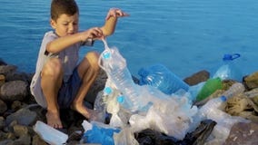 Λίγο παιδί εθελοντικό καθαρίζοντας επάνω την παραλία στον ωκεανό Ασφαλής έννοια οικολογίας Λίγο παιδί εθελοντικό καθαρίζοντας επάνω την παραλία στον ωκεανό Ασφαλής έννοια οικολογίας