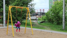 Λίγο όμορφο κορίτσι στα gumboots στην ταλάντευση στην παιδική χαρά φιλμ μικρού μήκους Λίγο όμορφο κορίτσι στα gumboots στην ταλάντευση στην παιδική χαρά φιλμ μικρού μήκους