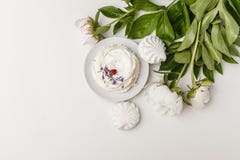 Λεπτά άσπρα peonies και κέικ σε ένα άσπρο υπόβαθρο στοκ φωτογραφία Λεπτά άσπρα peonies και κέικ σε ένα άσπρο υπόβαθρο στοκ φωτογραφία