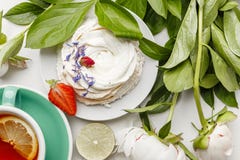 Λεπτά άσπρα peonies με το τσάι, το λεμόνι, τις ώριμα φράουλες και τα μπισκότα σε έναν άσπρο πίνακα στοκ φωτογραφία με δικαίωμα ελεύθερης χρήσης Λεπτά άσπρα peonies με το τσάι, το λεμόνι, τις ώριμα φράουλες και τα μπισκότα σε έναν άσπρο πίνακα στοκ φωτογραφία με δικαίωμα ελεύθερης χρήσης