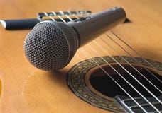 Λεπτομέρεια της κλασικών κιθάρας και του microfone στοκ εικόνα Λεπτομέρεια της κλασικών κιθάρας και του microfone στοκ εικόνα
