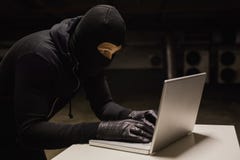 Ληστής στο γραφείο που χαράσσει ένα lap-top Στοκ Φωτογραφία Ληστής στο γραφείο που χαράσσει ένα lap-top Στοκ Φωτογραφία