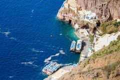 Λιμένας στην πόλη Fira στο νησί Santorini Γιοτ μεταξύ των βράχων και του Αιγαίου πελάγους στοκ εικόνα Λιμένας στην πόλη Fira στο νησί Santorini Γιοτ μεταξύ των βράχων και του Αιγαίου πελάγους στοκ εικόνα