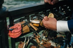 Λουκέτο με τα ονόματα των newlyweds και της νύφης και του νεόνυμφου χορταριών που στερεώνουν την κλειδαριά στοκ φωτογραφία Λουκέτο με τα ονόματα των newlyweds και της νύφης και του νεόνυμφου χορταριών που στερεώνουν την κλειδαριά στοκ φωτογραφία