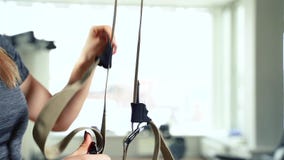 Λουριά TRX ικανότητας Νέα γυναίκα πρίν εκπαιδεύει στη γυμναστική απόθεμα βίντεο Λουριά TRX ικανότητας Νέα γυναίκα πρίν εκπαιδεύει στη γυμναστική απόθεμα βίντεο