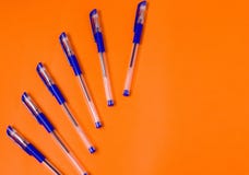 Μέρη των μπλε πλαστικών μανδρών ballpoint με το καπάκι, σε διαφανή εξαγωνική περίπτωση, στο πορτοκαλί υπόβαθρο στοκ εικόνα Μέρη των μπλε πλαστικών μανδρών ballpoint με το καπάκι, σε διαφανή εξαγωνική περίπτωση, στο πορτοκαλί υπόβαθρο στοκ εικόνα