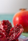 Μέρος ενός juicy ροδιού με τα σιτάρια της κινηματογράφησης σε πρώτο πλάνο Όμορφο μουτζουρωμένο σκηνικό στοκ φωτογραφίες με δικαίωμα ελεύθερης χρήσης Μέρος ενός juicy ροδιού με τα σιτάρια της κινηματογράφησης σε πρώτο πλάνο Όμορφο μουτζουρωμένο σκηνικό στοκ φωτογραφίες με δικαίωμα ελεύθερης χρήσης