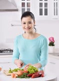 Μαγείρεμα γυναικών στη νέα κουζίνα που κατασκευάζει τα υγιή τρόφιμα με τα λαχανικά στοκ εικόνες Μαγείρεμα γυναικών στη νέα κουζίνα που κατασκευάζει τα υγιή τρόφιμα με τα λαχανικά στοκ εικόνες