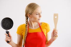 Μαγειρεύοντας τηγάνι και spatula εκμετάλλευσης γυναικών στοκ φωτογραφία με δικαίωμα ελεύθερης χρήσης Μαγειρεύοντας τηγάνι και spatula εκμετάλλευσης γυναικών στοκ φωτογραφία με δικαίωμα ελεύθερης χρήσης