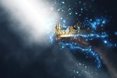 Μαγική εικόνα Mysteriousand του χεριού γυναικών ` s που κρατά μια χρυσή κορώνα στοκ εικόνα Μαγική εικόνα Mysteriousand του χεριού γυναικών ` s που κρατά μια χρυσή κορώνα στοκ εικόνα