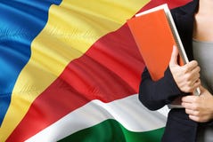 Μαθαίνοντας Seychellois γλωσσική έννοια Νέα γυναίκα που στέκεται με τη σημαία των Σεϋχελλών στο υπόβαθρο Βιβλία εκμετάλλευσης δασ στοκ φωτογραφίες με δικαίωμα ελεύθερης χρήσης Μαθαίνοντας Seychellois γλωσσική έννοια Νέα γυναίκα που στέκεται με τη σημαία των Σεϋχελλών στο υπόβαθρο Βιβλία εκμετάλλευσης δασ στοκ φωτογραφίες με δικαίωμα ελεύθερης χρήσης