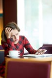 Ματαιωμένη νέα συνεδρίαση γυναικών στο coffeeshop στοκ εικόνες Ματαιωμένη νέα συνεδρίαση γυναικών στο coffeeshop στοκ εικόνες