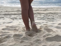 Μαυρισμένα πόδια των προκλητικών γυναικών στην άσπρη λεπτή άμμο της μοναδικής παραλίας Karon Phuket στο υπόβαθρο της θάλασσας και στοκ φωτογραφίες Μαυρισμένα πόδια των προκλητικών γυναικών στην άσπρη λεπτή άμμο της μοναδικής παραλίας Karon Phuket στο υπόβαθρο της θάλασσας και στοκ φωτογραφίες