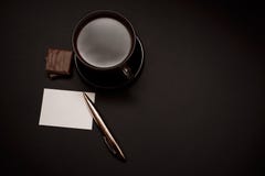 Μαύρος, φυσικός, ευώδης καφές στο διαφανές φλυτζάνι σε ένα μαύρο υπόβαθρο, με τη σοκολάτα γάλακτος στοκ εικόνες Μαύρος, φυσικός, ευώδης καφές στο διαφανές φλυτζάνι σε ένα μαύρο υπόβαθρο, με τη σοκολάτα γάλακτος στοκ εικόνες