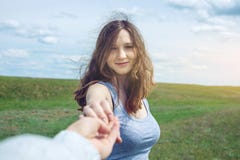 Με ακολουθήστε, ελκυστικό κορίτσι brunette που κρατά το χέρι των μολύβδων σε έναν καθαρό πράσινο τομέα, στέπα με τα σύννεφα στοκ φωτογραφία με δικαίωμα ελεύθερης χρήσης Με ακολουθήστε, ελκυστικό κορίτσι brunette που κρατά το χέρι των μολύβδων σε έναν καθαρό πράσινο τομέα, στέπα με τα σύννεφα στοκ φωτογραφία με δικαίωμα ελεύθερης χρήσης
