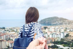 Με ακολουθήστε, ελκυστικό κορίτσι brunette που κρατά τους μολύβδους χεριών στην παράκτια πόλη από ένα ύψος στοκ φωτογραφία με δικαίωμα ελεύθερης χρήσης Με ακολουθήστε, ελκυστικό κορίτσι brunette που κρατά τους μολύβδους χεριών στην παράκτια πόλη από ένα ύψος στοκ φωτογραφία με δικαίωμα ελεύθερης χρήσης