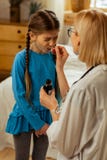 Με κοντά μαλλιά γιατρός που δίνει ένα σιρόπι λαιμού σε ένα κορίτσι στοκ εικόνες Με κοντά μαλλιά γιατρός που δίνει ένα σιρόπι λαιμού σε ένα κορίτσι στοκ εικόνες