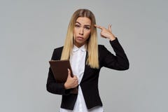 Μεγάλο πορτρέτο στούντιο της νέας μακρυμάλλους επιχειρησιακής γυναίκας με έναν φάκελλο αρχείων στα χέρια του με μια ματαιωμένη έκ στοκ φωτογραφία με δικαίωμα ελεύθερης χρήσης Μεγάλο πορτρέτο στούντιο της νέας μακρυμάλλους επιχειρησιακής γυναίκας με έναν φάκελλο αρχείων στα χέρια του με μια ματαιωμένη έκ στοκ φωτογραφία με δικαίωμα ελεύθερης χρήσης