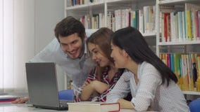 Μελέτη δύο κοριτσιών για το lap-top στη βιβλιοθήκη στοκ εικόνα με δικαίωμα ελεύθερης χρήσης Μελέτη δύο κοριτσιών για το lap-top στη βιβλιοθήκη στοκ εικόνα με δικαίωμα ελεύθερης χρήσης
