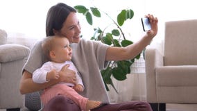 Μητέρα που παίρνει selfie με το κοριτσάκι που χρησιμοποιεί το κινητό τηλέφωνο απόθεμα βίντεο Μητέρα που παίρνει selfie με το κοριτσάκι που χρησιμοποιεί το κινητό τηλέφωνο απόθεμα βίντεο
