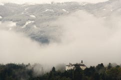 Μια άποψη Ambras Castle στο Ίνσμπρουκ, Αυστρία που περιβάλλεται από τα δέντρα και στα πλαίσια των βουνών στοκ φωτογραφίες με δικαίωμα ελεύθερης χρήσης Μια άποψη Ambras Castle στο Ίνσμπρουκ, Αυστρία που περιβάλλεται από τα δέντρα και στα πλαίσια των βουνών στοκ φωτογραφίες με δικαίωμα ελεύθερης χρήσης