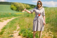 Μια γυναίκα να κάνει ωτοστόπ από το δρόμο κατά τη διάρκεια της ηλιόλουστης ημέρας στοκ φωτογραφίες με δικαίωμα ελεύθερης χρήσης Μια γυναίκα να κάνει ωτοστόπ από το δρόμο κατά τη διάρκεια της ηλιόλουστης ημέρας στοκ φωτογραφίες με δικαίωμα ελεύθερης χρήσης
