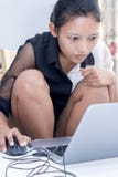 Μια γυναίκα που εργάζεται στο lap-top της στο κρεβάτι στοκ φωτογραφία Μια γυναίκα που εργάζεται στο lap-top της στο κρεβάτι στοκ φωτογραφία