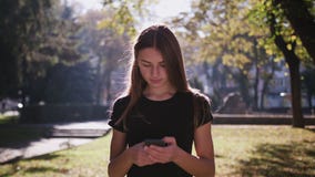Μια ελκυστική νέα κυρία που χρησιμοποιεί ένα τηλέφωνο στην πόλη Μέσος πυροβολισμός απόθεμα βίντεο Μια ελκυστική νέα κυρία που χρησιμοποιεί ένα τηλέφωνο στην πόλη Μέσος πυροβολισμός απόθεμα βίντεο