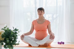 Μια ευρωπαϊκή έγκυος γυναίκα με ρόδινη tshirt do yoga ασκεί για το carehealth της και το αγέννητο παιδί στην ελαφριά κρεβατοκάμαρ Στοκ φωτογραφίες με δικαίωμα ελεύθερης χρήσης Μια ευρωπαϊκή έγκυος γυναίκα με ρόδινη tshirt do yoga ασκεί για το carehealth της και το αγέννητο παιδί στην ελαφριά κρεβατοκάμαρ Στοκ φωτογραφίες με δικαίωμα ελεύθερης χρήσης