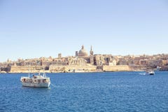 Μια καταπληκτική πανοραμική άποψη μιας αρχαίας πρωτεύουσας Valletta στη Μάλτα με μια βάρκα στη θάλασσα Στοκ Φωτογραφίες Μια καταπληκτική πανοραμική άποψη μιας αρχαίας πρωτεύουσας Valletta στη Μάλτα με μια βάρκα στη θάλασσα Στοκ Φωτογραφίες