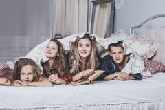 Μια μεγάλη ευτυχής οικογένεια Το Mom διαβάζει ένα βιβλίο στα παιδιά τους στο κρεβάτι στοκ φωτογραφία με δικαίωμα ελεύθερης χρήσης Μια μεγάλη ευτυχής οικογένεια Το Mom διαβάζει ένα βιβλίο στα παιδιά τους στο κρεβάτι στοκ φωτογραφία με δικαίωμα ελεύθερης χρήσης