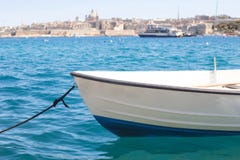 Μια μικρή βάρκα στη θάλασσα με μια καταπληκτική πανοραμική άποψη μιας αρχαίας πρωτεύουσας Valletta στη Μάλτα στο υπόβαθρο Στοκ Εικόνες Μια μικρή βάρκα στη θάλασσα με μια καταπληκτική πανοραμική άποψη μιας αρχαίας πρωτεύουσας Valletta στη Μάλτα στο υπόβαθρο Στοκ Εικόνες