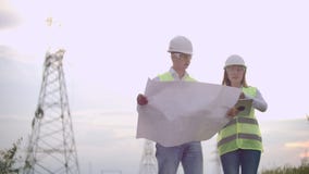 Μια ομάδα μηχανικών σε υψηλής τάσεως εγκαταστάσεις παραγωγής ενέργειας με μια ταμπλέτα και τα σχέδια περπατούν και συζητούν ένα σ φιλμ μικρού μήκους Μια ομάδα μηχανικών σε υψηλής τάσεως εγκαταστάσεις παραγωγής ενέργειας με μια ταμπλέτα και τα σχέδια περπατούν και συζητούν ένα σ φιλμ μικρού μήκους