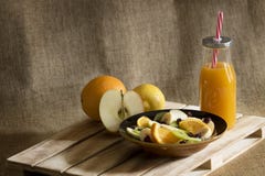 Μια σαλάτα φρούτων, ένα μπουκάλι του χυμού μάγκο και μερικά κομμάτια τ στοκ εικόνες με δικαίωμα ελεύθερης χρήσης Μια σαλάτα φρούτων, ένα μπουκάλι του χυμού μάγκο και μερικά κομμάτια τ στοκ εικόνες με δικαίωμα ελεύθερης χρήσης