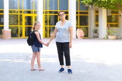 Μικρό κορίτσι με τη σχολική τσάντα ή satchel που περπατά στο σχολείο με τη γιαγιά στοκ εικόνες με δικαίωμα ελεύθερης χρήσης Μικρό κορίτσι με τη σχολική τσάντα ή satchel που περπατά στο σχολείο με τη γιαγιά στοκ εικόνες με δικαίωμα ελεύθερης χρήσης