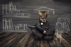 Μικρό παιδί παιδιών στα γυαλιά που διαβάζει το βιβλίο πέρα από το σχολικό μαύρο πίνακα Στοκ Εικόνα Μικρό παιδί παιδιών στα γυαλιά που διαβάζει το βιβλίο πέρα από το σχολικό μαύρο πίνακα Στοκ Εικόνα