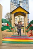 Μικρό παιδί στην παιδική χαρά στο προαύλιο στοκ εικόνα Μικρό παιδί στην παιδική χαρά στο προαύλιο στοκ εικόνα