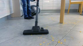 Μικρό παιδί που σκουπίζει το πάτωμα κουζινών με ηλεκτρική σκούπα Τακτοποιεί τις νιφάδες καλαμποκιού που διασκορπίζονται στο γκρίζ απόθεμα βίντεο Μικρό παιδί που σκουπίζει το πάτωμα κουζινών με ηλεκτρική σκούπα Τακτοποιεί τις νιφάδες καλαμποκιού που διασκορπίζονται στο γκρίζ απόθεμα βίντεο
