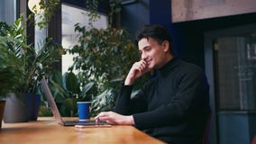 Μικτό άτομο φυλών που εργάζεται με το lap-top και το έξυπνο τηλέφωνο στον καφέ απόθεμα βίντεο Μικτό άτομο φυλών που εργάζεται με το lap-top και το έξυπνο τηλέφωνο στον καφέ απόθεμα βίντεο