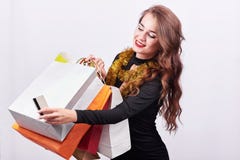 Μοντέρνη νέα γυναίκα brunette που κρατά τις ζωηρόχρωμες τσάντες αγορών και την πιστωτική κάρτα στοκ εικόνα με δικαίωμα ελεύθερης χρήσης Μοντέρνη νέα γυναίκα brunette που κρατά τις ζωηρόχρωμες τσάντες αγορών και την πιστωτική κάρτα στοκ εικόνα με δικαίωμα ελεύθερης χρήσης