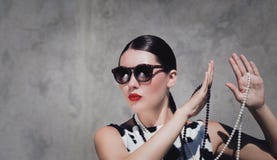 Μοντέρνη όμορφη γυναίκα με τα γυαλιά ηλίου, τα περιδέραια μαργαριταριών και τα φωτεινά χρωματισμένα χείλια στοκ εικόνα Μοντέρνη όμορφη γυναίκα με τα γυαλιά ηλίου, τα περιδέραια μαργαριταριών και τα φωτεινά χρωματισμένα χείλια στοκ εικόνα