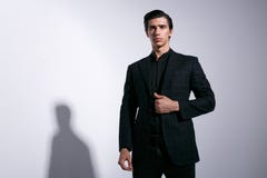 Μοντέρνο νέο όμορφο άτομο σε ένα μοντέρνο κοστούμι, που κρατά το χέρι στο σακάκι ελεγκτών, που απομονώνεται στο άσπρο υπόβαθρο στοκ φωτογραφία Μοντέρνο νέο όμορφο άτομο σε ένα μοντέρνο κοστούμι, που κρατά το χέρι στο σακάκι ελεγκτών, που απομονώνεται στο άσπρο υπόβαθρο στοκ φωτογραφία