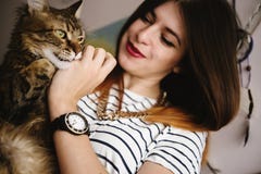Μοντέρνο παιχνίδι γυναικών hipster με τη γάτα της στο σύγχρονο δωμάτιο στοκ εικόνες Μοντέρνο παιχνίδι γυναικών hipster με τη γάτα της στο σύγχρονο δωμάτιο στοκ εικόνες