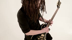 Μοντέρνος σόλο κιθαρίστας με τα dreadlocks στο κεφάλι του και στα μαύρα ενδύματα σε ένα άσπρο παιχνίδι υποβάθρου εκφραστικά φιλμ μικρού μήκους Μοντέρνος σόλο κιθαρίστας με τα dreadlocks στο κεφάλι του και στα μαύρα ενδύματα σε ένα άσπρο παιχνίδι υποβάθρου εκφραστικά φιλμ μικρού μήκους