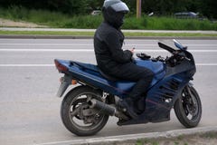 Μοτοσυκλετιστής που οδηγά στη μοτοσικλέτα του στο ηλιοβασίλεμα στοκ εικόνες Μοτοσυκλετιστής που οδηγά στη μοτοσικλέτα του στο ηλιοβασίλεμα στοκ εικόνες