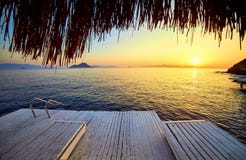 Μπανγκαλόου στη θάλασσα στο ηλιοβασίλεμα Ξύλινα περίπτερα στην ακτή μιας αμμώδους παραλίας - Bodrum, Τουρκία στοκ φωτογραφίες με δικαίωμα ελεύθερης χρήσης Μπανγκαλόου στη θάλασσα στο ηλιοβασίλεμα Ξύλινα περίπτερα στην ακτή μιας αμμώδους παραλίας - Bodrum, Τουρκία στοκ φωτογραφίες με δικαίωμα ελεύθερης χρήσης
