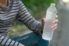 Μπουκάλι νερό ασιατικής ατόμων συνεδρίασης και εκμετάλλευσης στοκ εικόνα με δικαίωμα ελεύθερης χρήσης Μπουκάλι νερό ασιατικής ατόμων συνεδρίασης και εκμετάλλευσης στοκ εικόνα με δικαίωμα ελεύθερης χρήσης