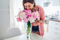 Μυρίζοντας ανθοδέσμη γυναικών των peonies Νοικοκυρά που απολαμβάνει το ντεκόρ και το εσωτερικό της κουζίνας home sweet στοκ εικόνα με δικαίωμα ελεύθερης χρήσης Μυρίζοντας ανθοδέσμη γυναικών των peonies Νοικοκυρά που απολαμβάνει το ντεκόρ και το εσωτερικό της κουζίνας home sweet στοκ εικόνα με δικαίωμα ελεύθερης χρήσης